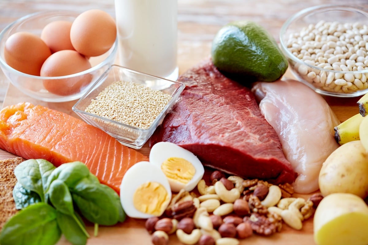 Fresh eggs, meat, fish, beans, fruits, nuts and vegetables on the table.