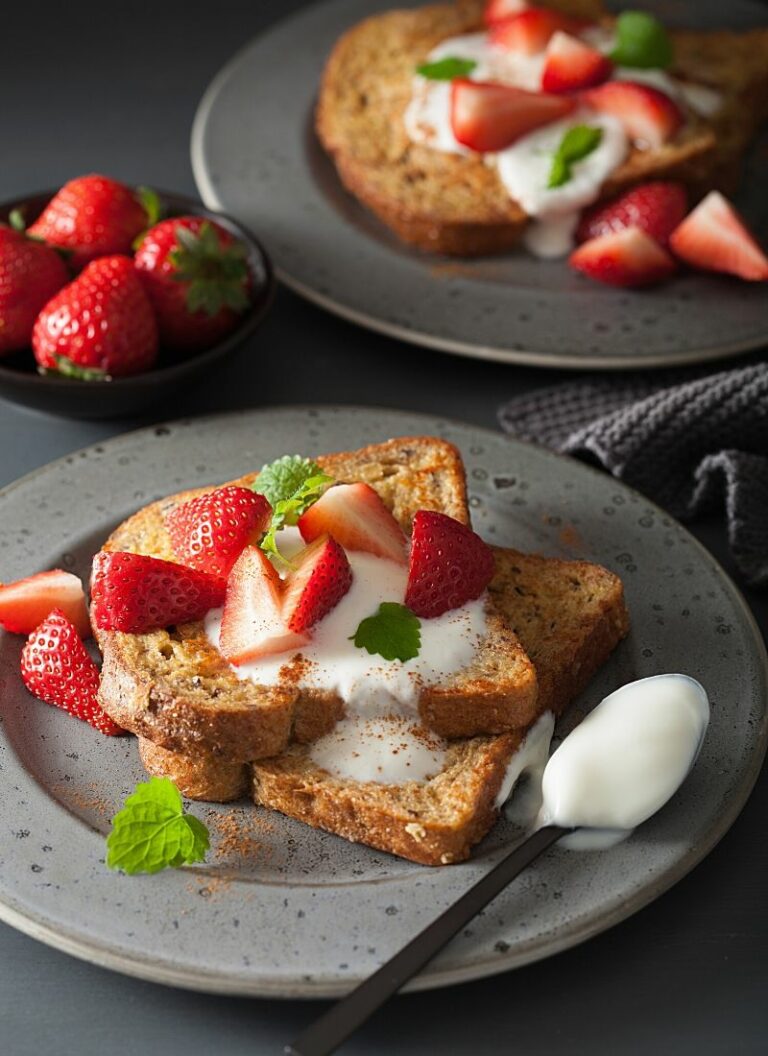 A plate of keto French toast with strawberries and cream.