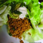 Lettuce wraps with turmeric-infused ground beef on a white plate.