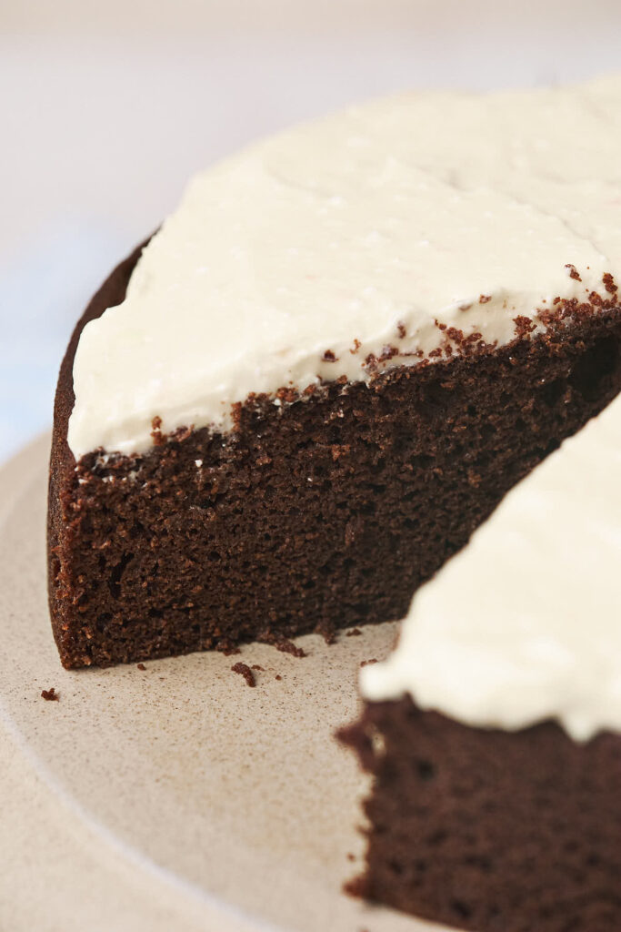 Chocolate cake with a luscious ricotta frosting, one slice removed.
