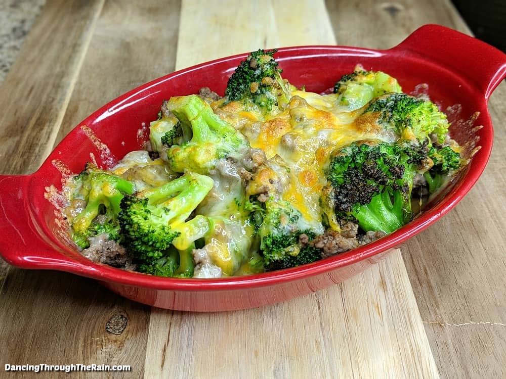 Ground beef and broccoli bake in a red dish.