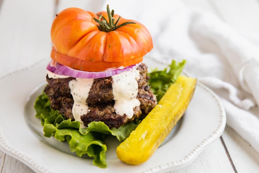 Grilled keto burger on a white plate.