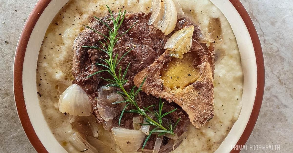 A picture of an easy beef shank slow cooker recipe over cauliflower mash with rosemary.