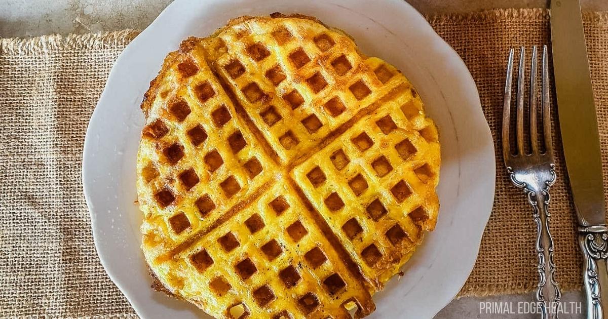 Waffles on a plate with a fork and knife.