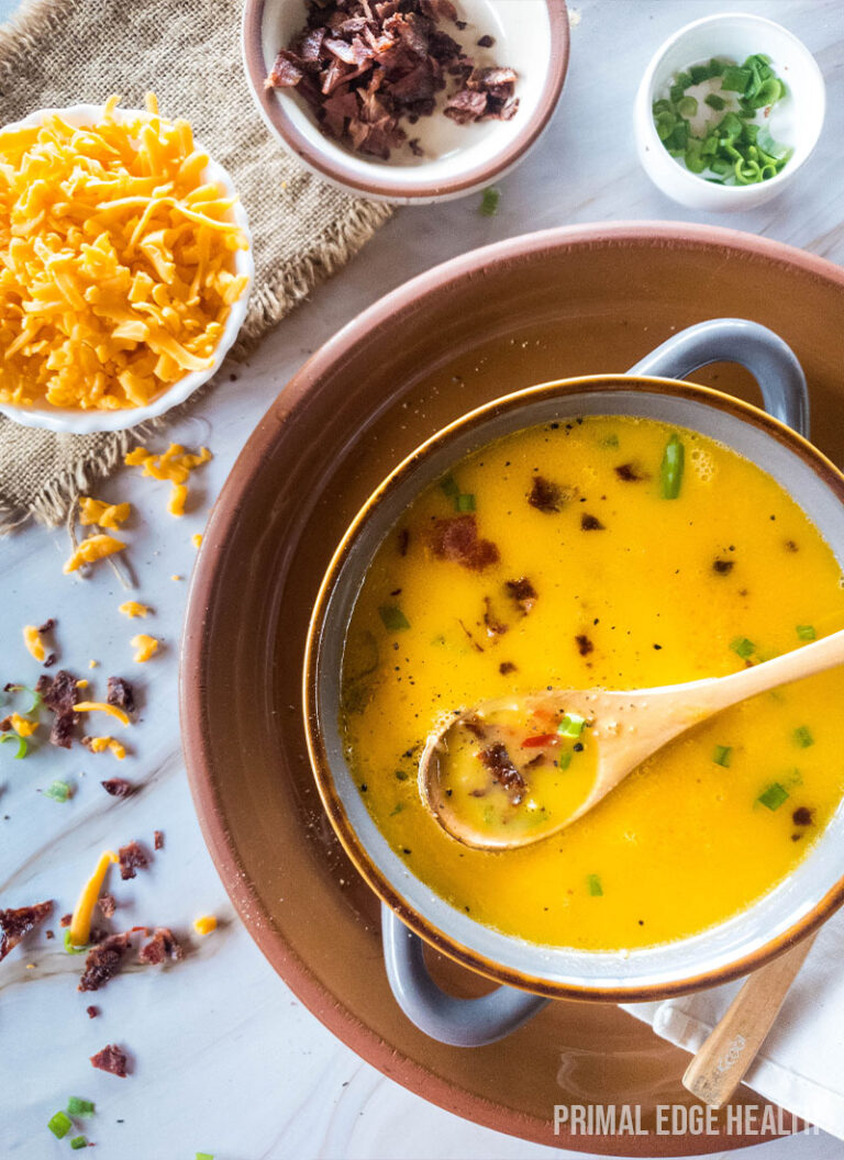 A bowl of creamy beer cheese soup, served with extra toppings.