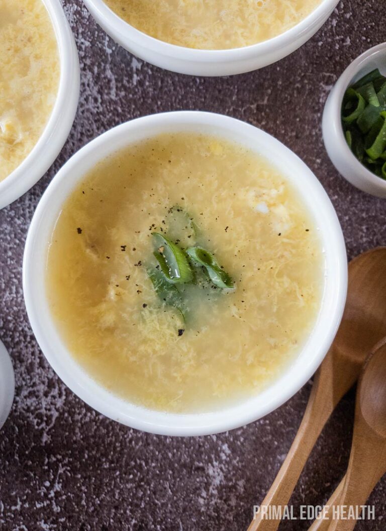 A bowl of egg drop soup, garnished with green onions.