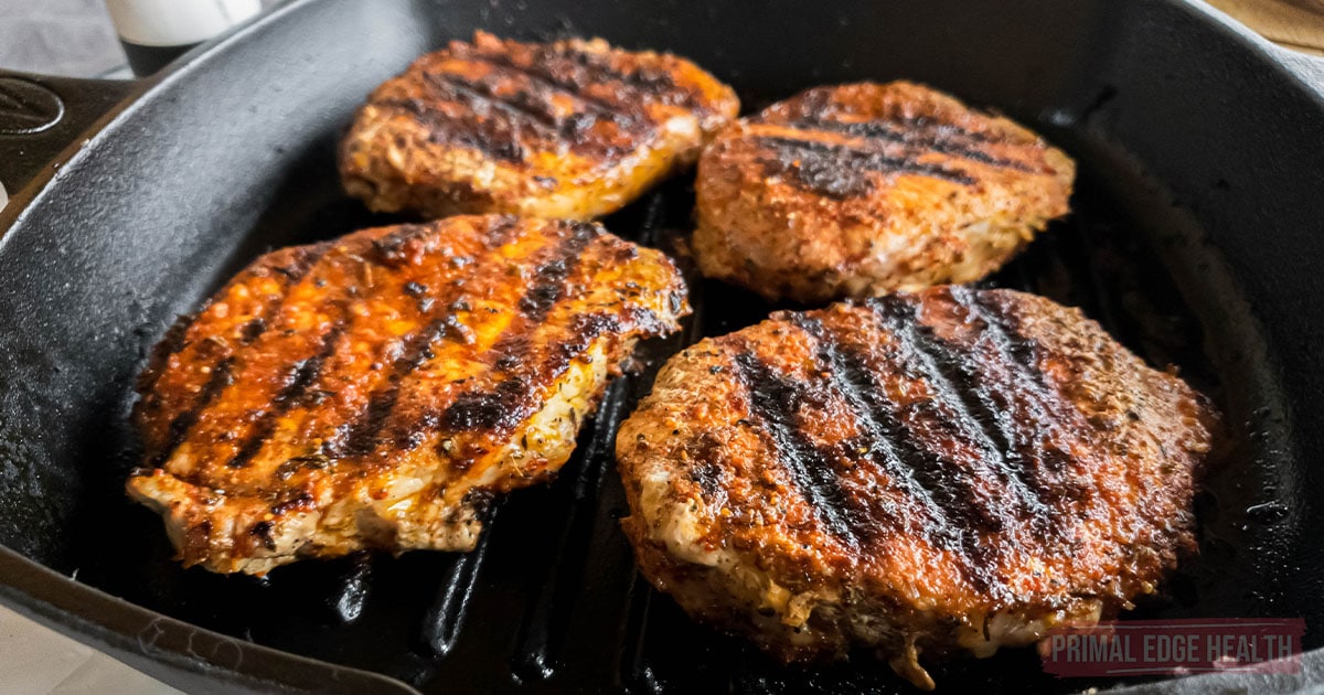 Four blackened pork chops recipe in cast iron grill pan.