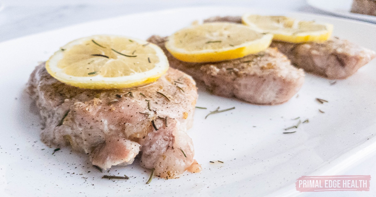 A picture of Lemon Pepper Pork Chops with rosemary garnish.