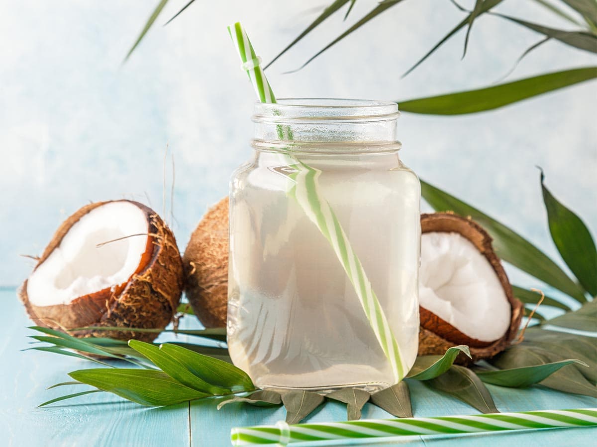 Coconut water in glass with straw.