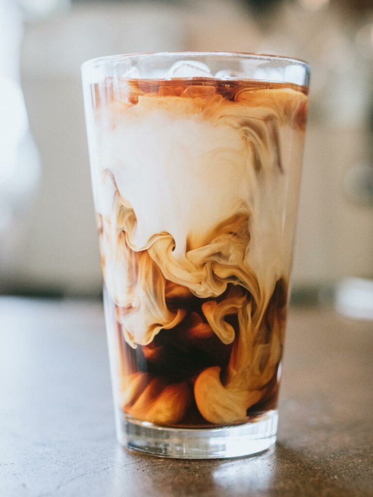 A glass of iced cold brew with milk on a hot summer day.