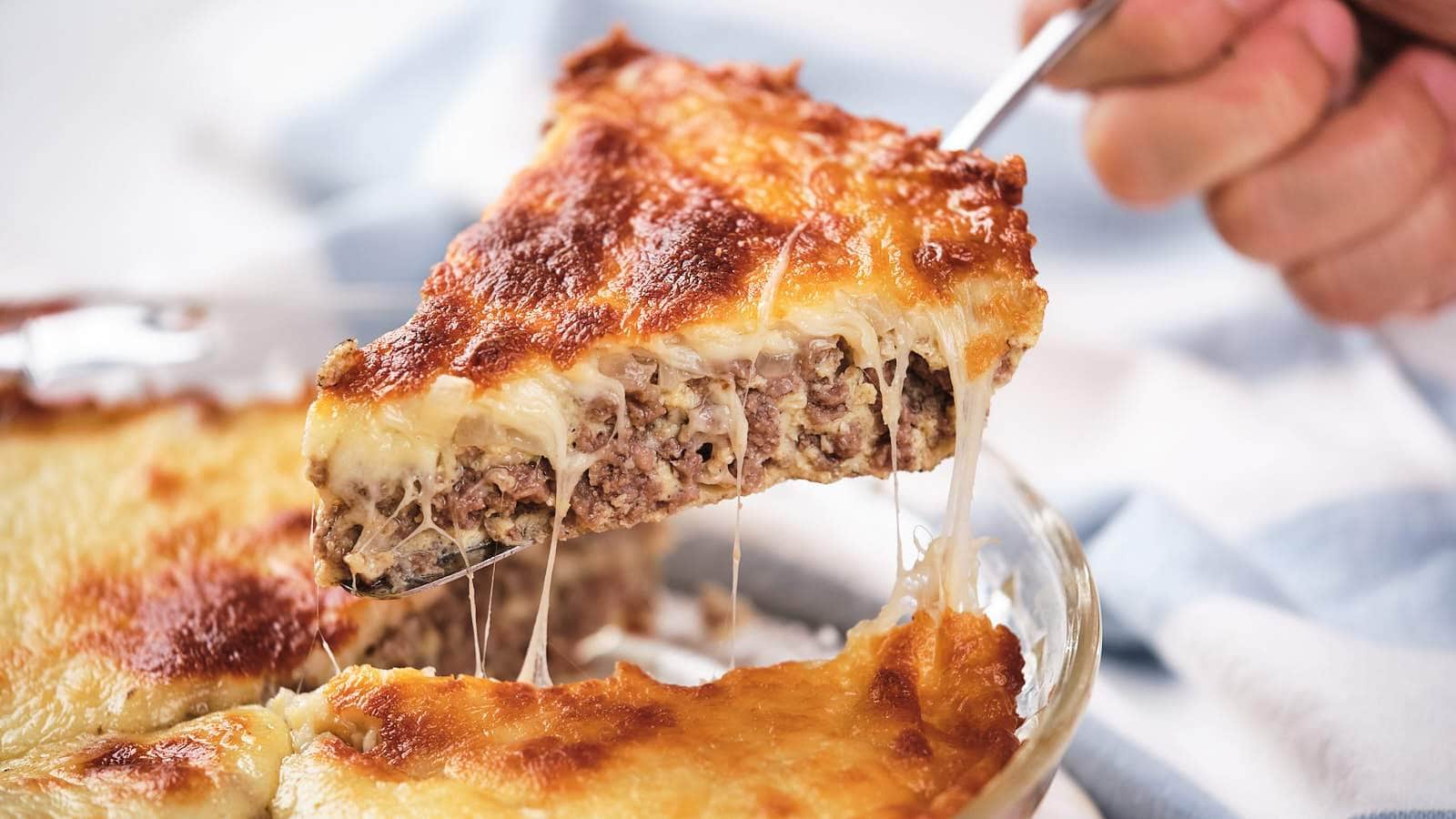 A slice of lasagna being lifted, showing layers of meat and melted cheese.
