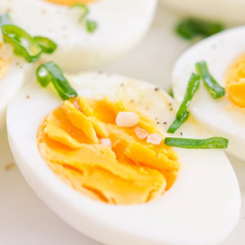 A close-up image of hard boiled eggs sliced open in half.