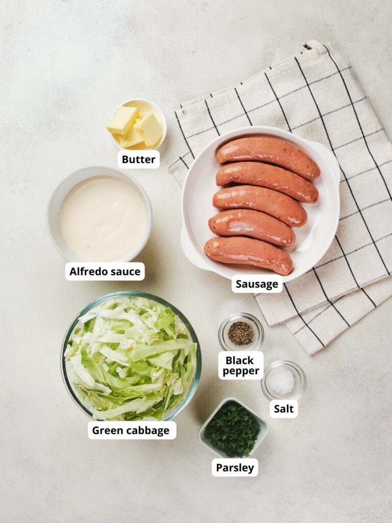 Ingredients of cabbage and sausage alfredo on a countertop.