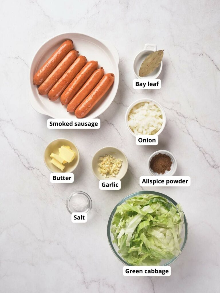 Ingredients of fried cabbage and sausage on a countertop.
