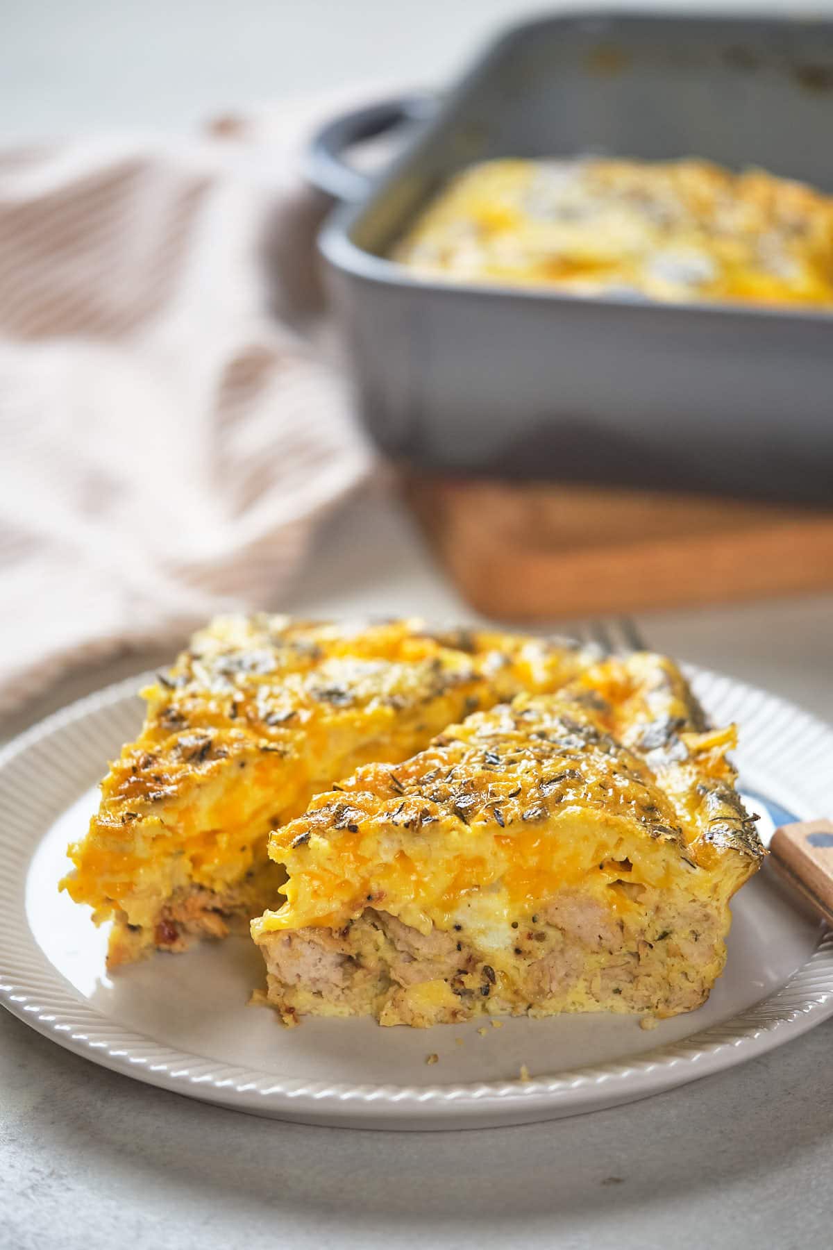 A plate with two servings of egg casserole containing vegetables and meat.