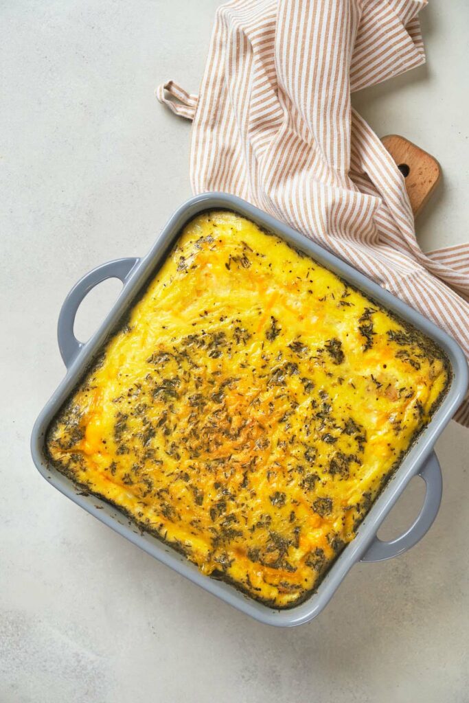 Square baking dish with a golden brown and herb-topped baked dish.