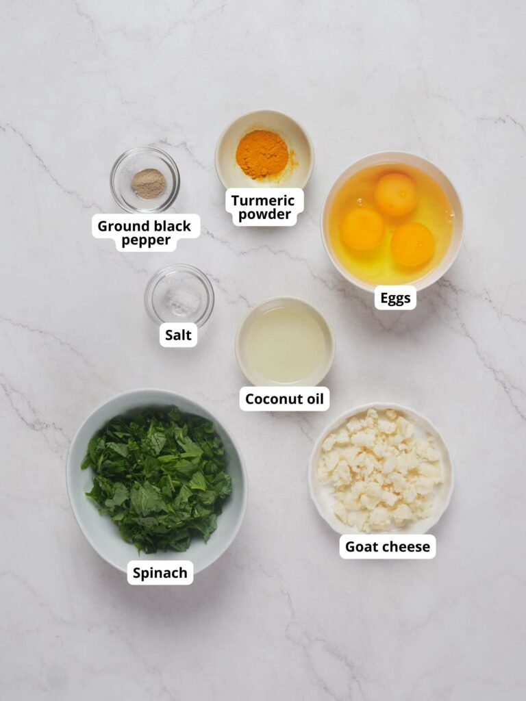 Cheese and spinach omelet ingredients on a marble surface.