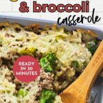 A close-up of a cheesy ground beef and broccoli casserole in a baking dish, with a wooden spoon.