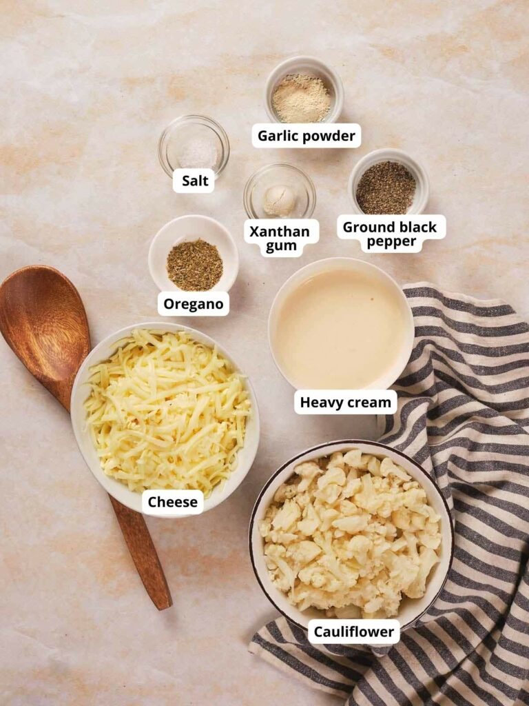 Ingredients for keto cauliflower mac and cheese are laid out on a countertop.