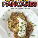 Plate of pancakes topped with white sauce and chopped green onions on a white dish.