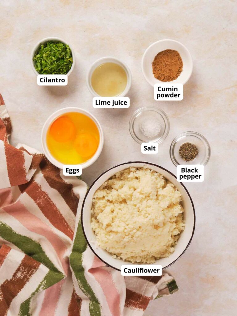 Ingredients for cauliflower tortilla. A striped cloth is placed next to the ingredients.