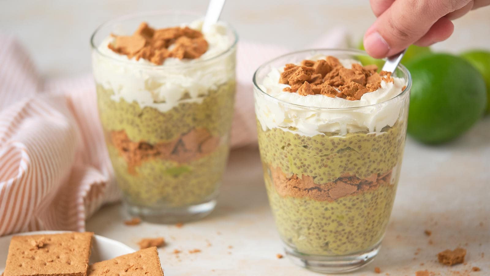 Key Lime Chia Pudding in glass bowl with wooden spoon.