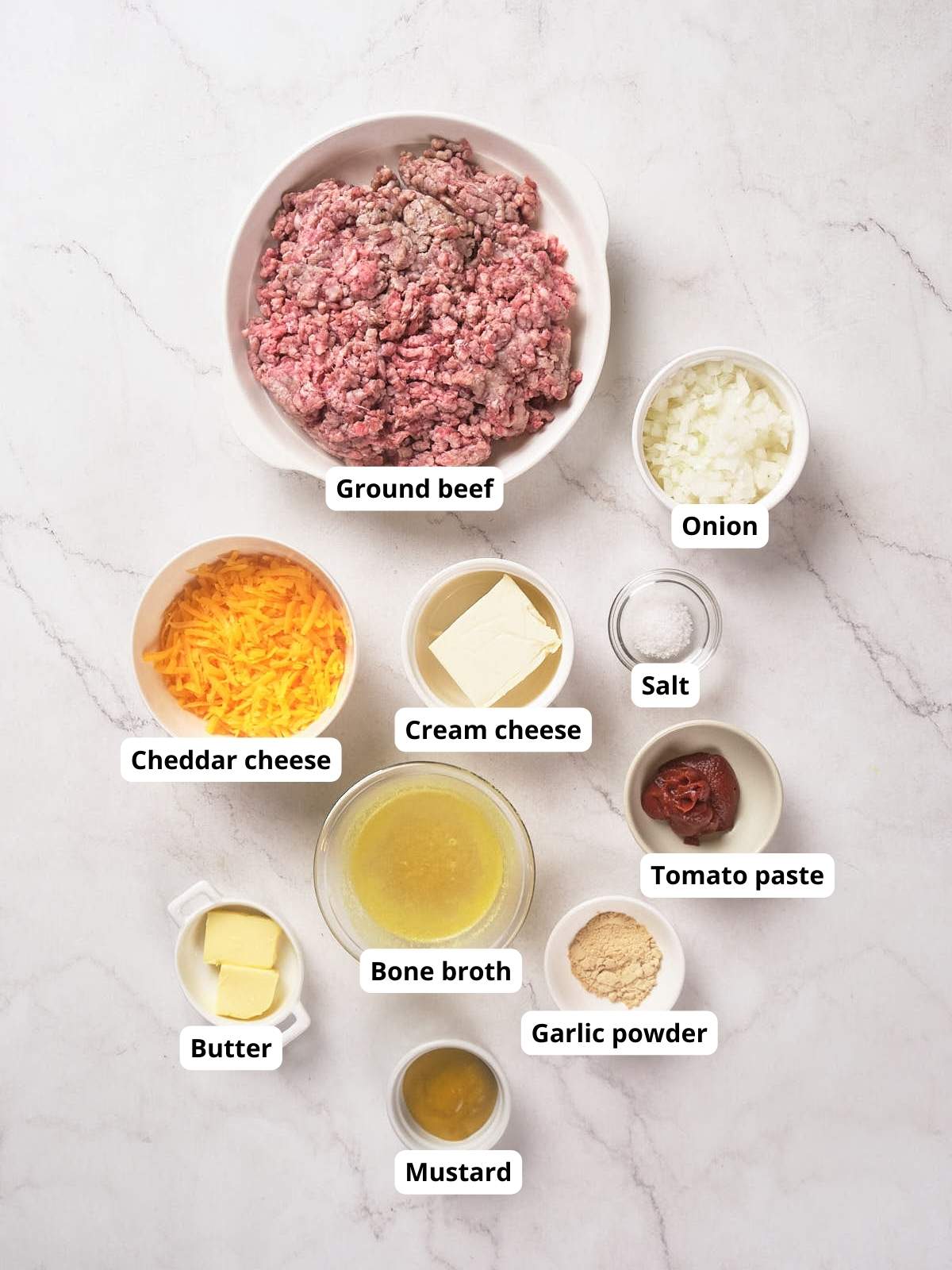 Ingredients for cheeseburger skillet arranged on a marble surface.