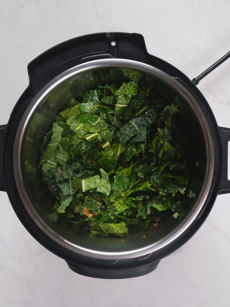 Chopped greens in an electric pressure cooker pot.