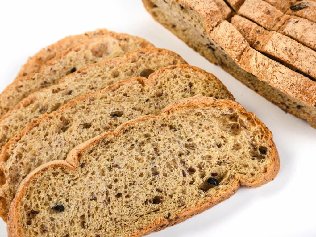 Slices of whole grain bread with visible seeds on a white background.