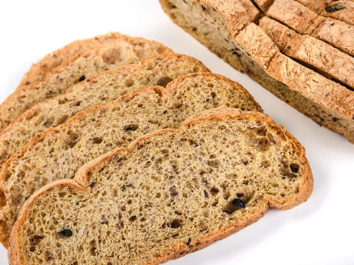 Slices of whole grain bread with visible seeds on a white background.