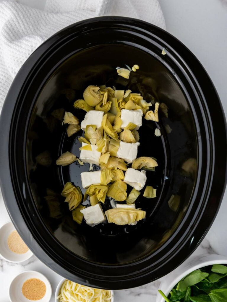 Slow cooker with artichoke hearts and cream cheese.