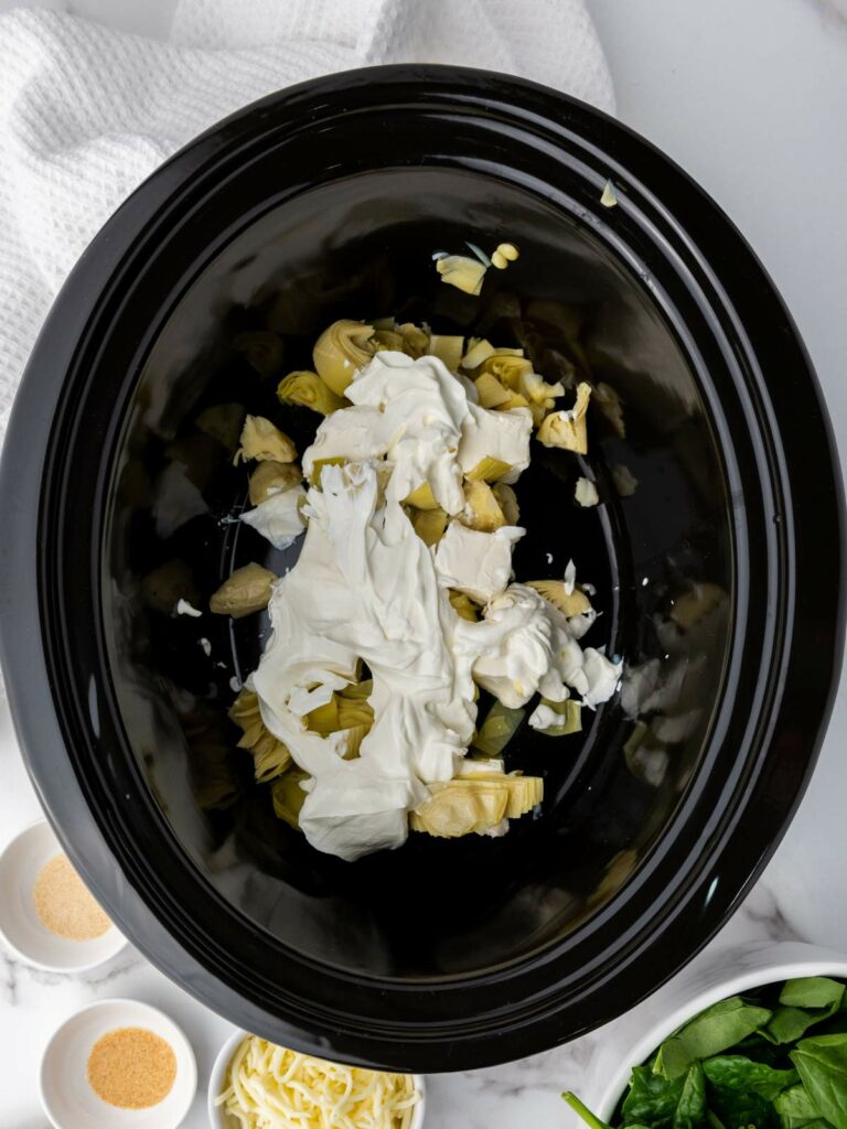 Slow cooker with cream cheese and artichoke hearts.