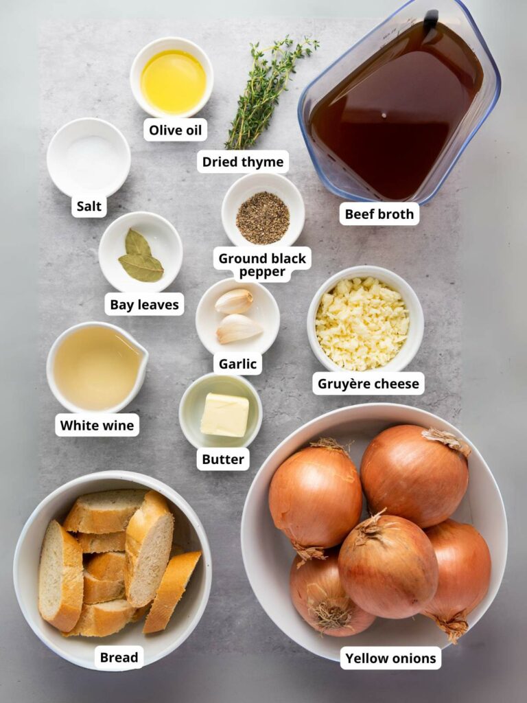 Ingredients for French onion soup arranged on a surface.