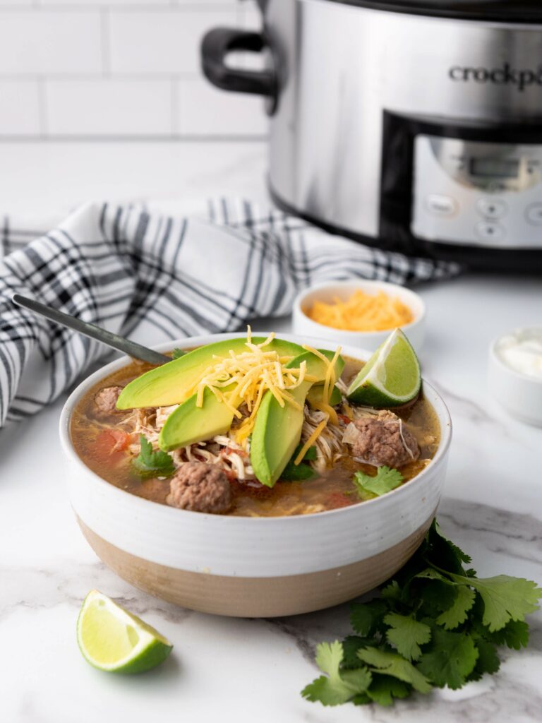 Bowl of taco soup and a slow cooker in the background.