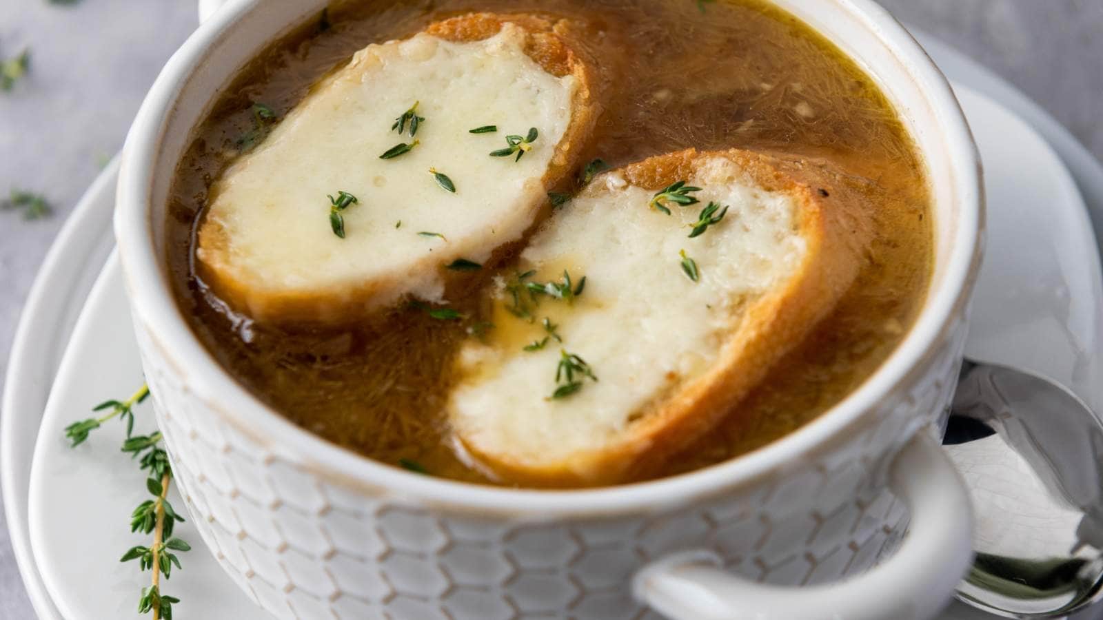 French onion soup topped with two slices of baguette and melted cheese.