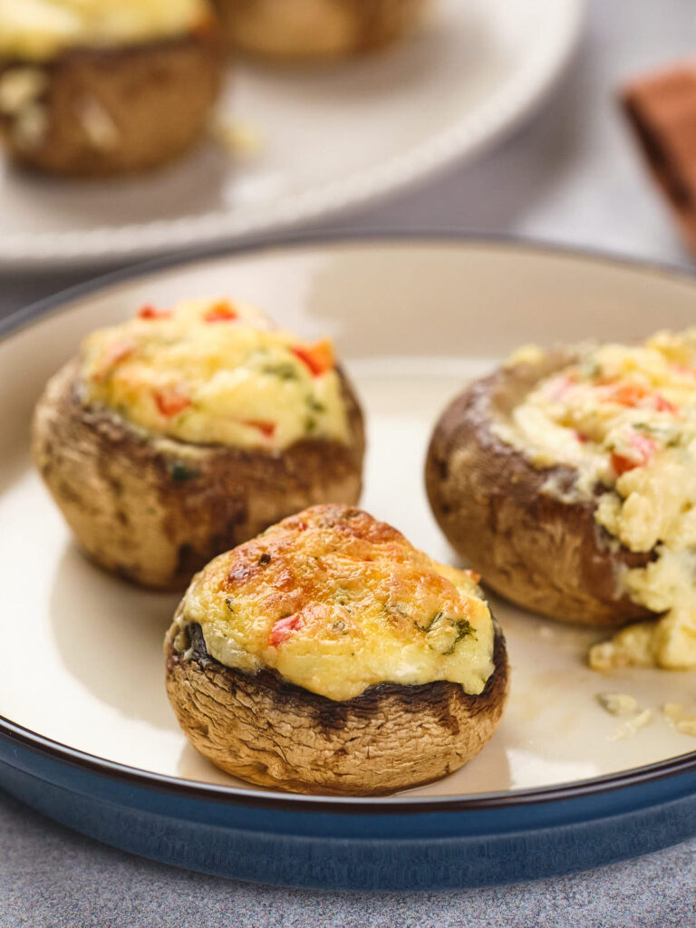 Stuffed mushrooms filled with a creamy mixture, topped with a golden-brown crust.