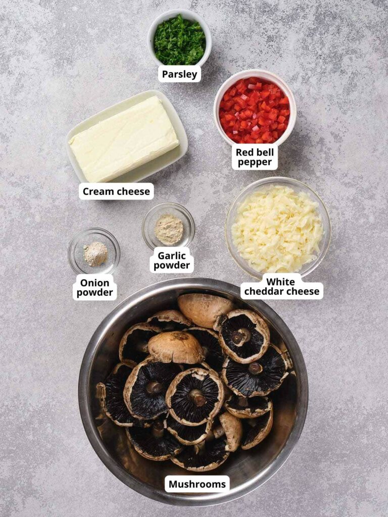 Ingredients for stuffed mushrooms arranged on a textured surface.