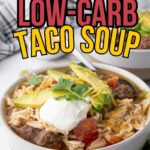 Bowl of low-carb taco soup topped with sliced avocado, sour cream, shredded cheese, and cilantro.