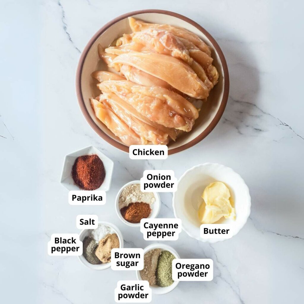 Ingredients for blackened chicken tenders on a marble surface.