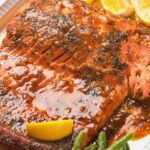 Honey mustard glazed salmon with a glazed seasoning on a white plate.